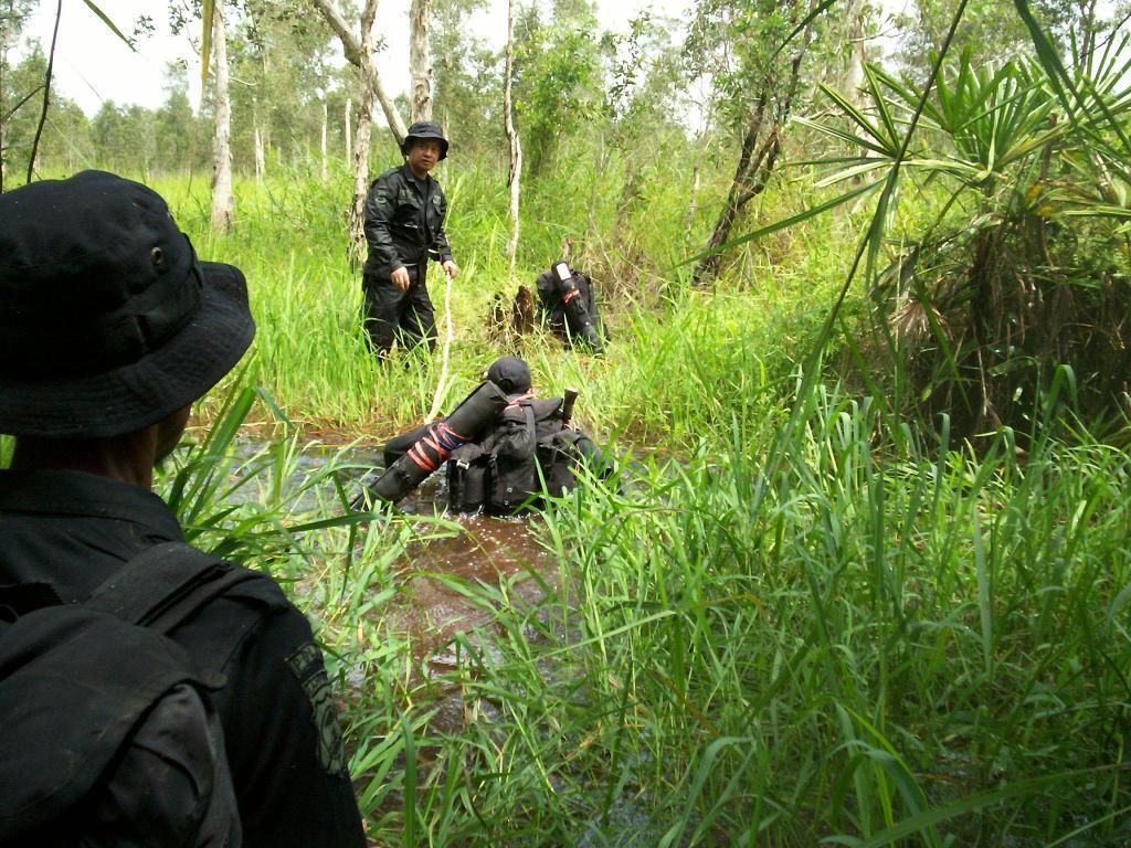 RPU members cross river in route to apprehend illegal logger